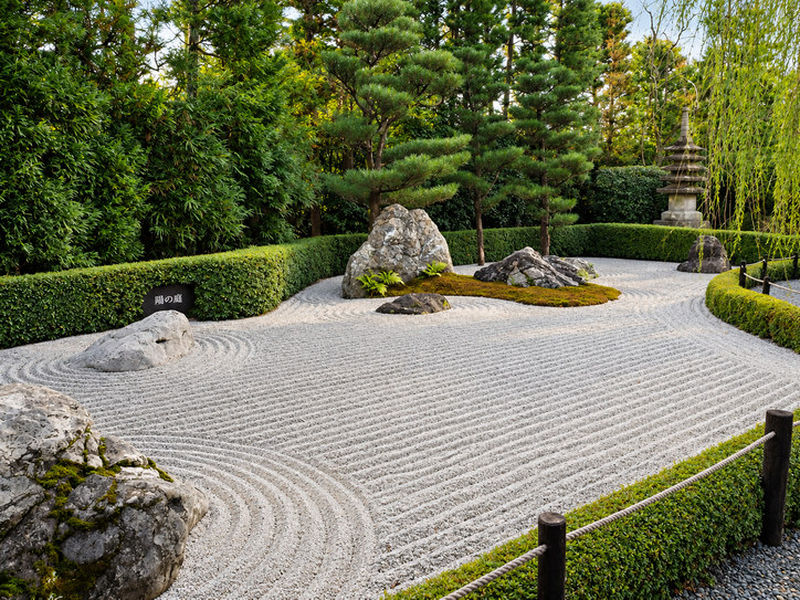 jardín zen de rocas y grava con setos a su alrededor